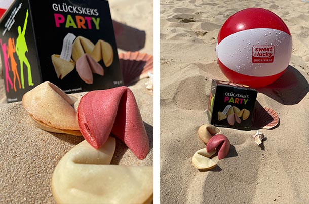 Fruchtige Sommer-Glückskekse im Sand mit Muscheln und Wasserball