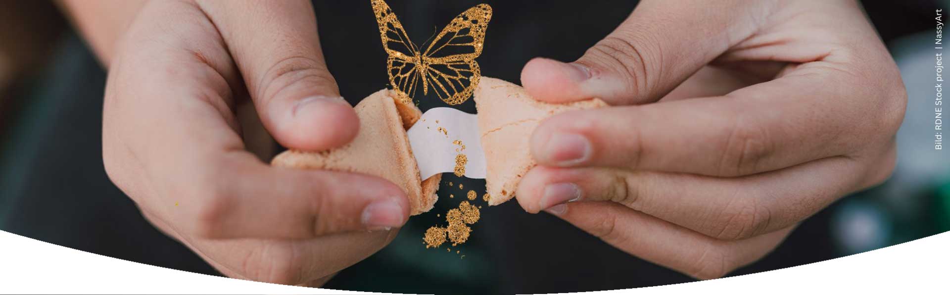 Ein Glückskeks wird geöffnet und heraus kommt ein golden glitzernder Schmetterling zum Thema Glückskekse und Achtsamkeit