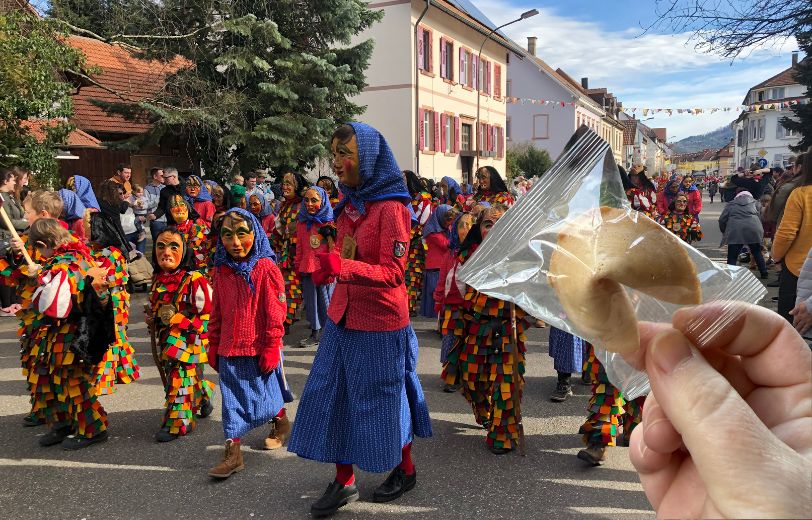 Faschingsumzug mit Hexe und Glückskeks im Vordergrund